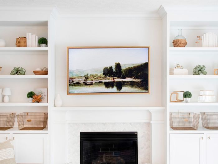 Neutral colored entertainment center with a frame around a TV to make it look like artwork.