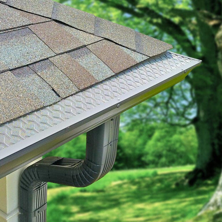 A HomeCraft gutter guard on the roof of a house near green trees.