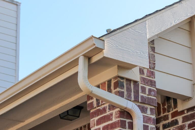 Side of a brick house showing the gutter