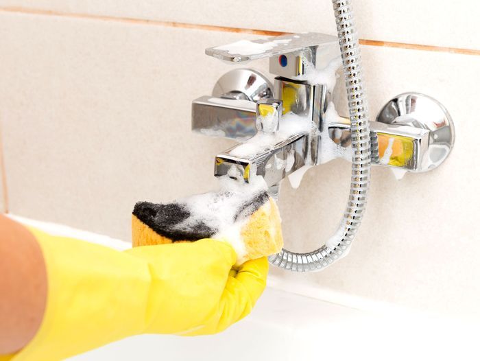 Sponge being used to clean water tap